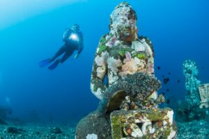 diver near underwater statue